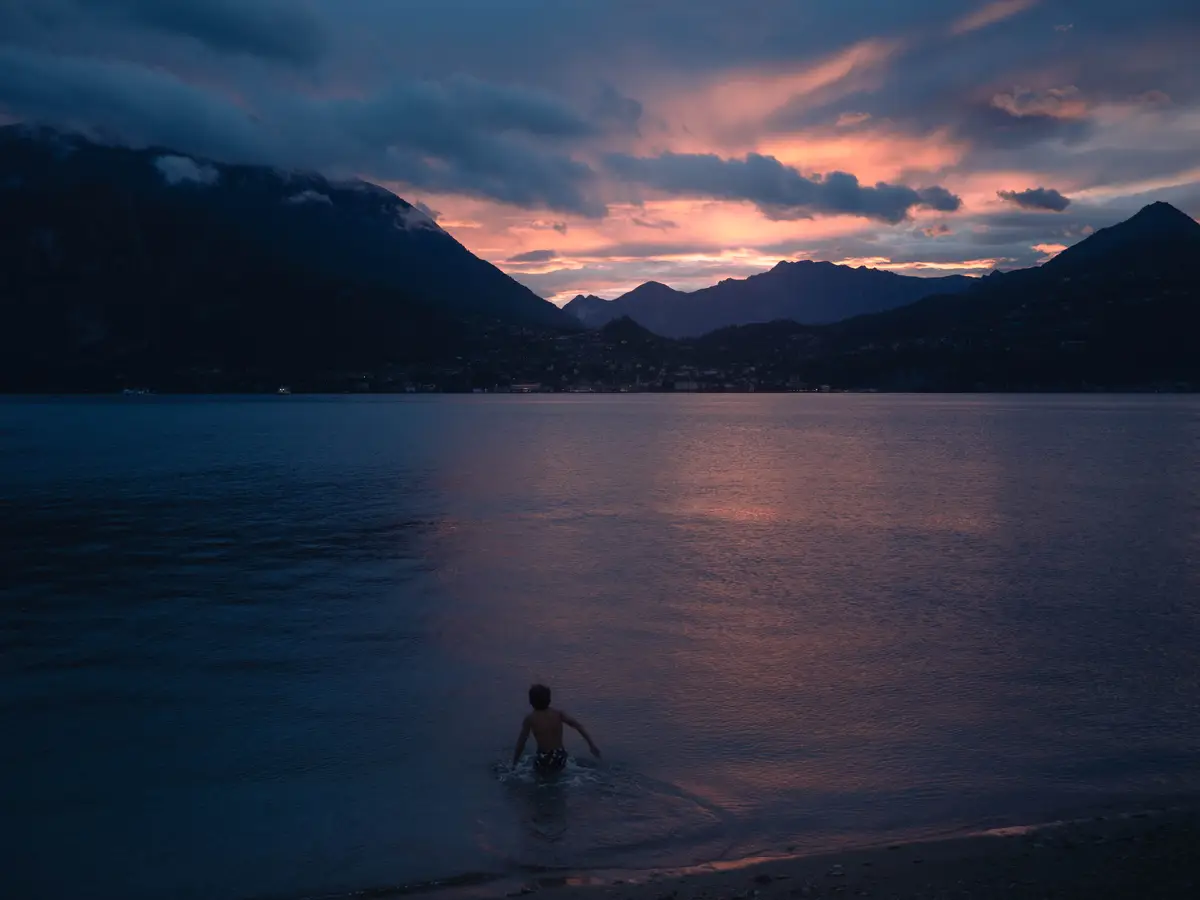 A teenager goes for a swim in the sunset