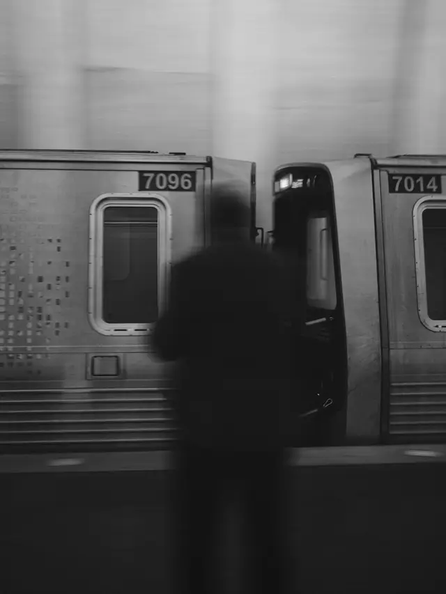 A man watches as a train speeds by